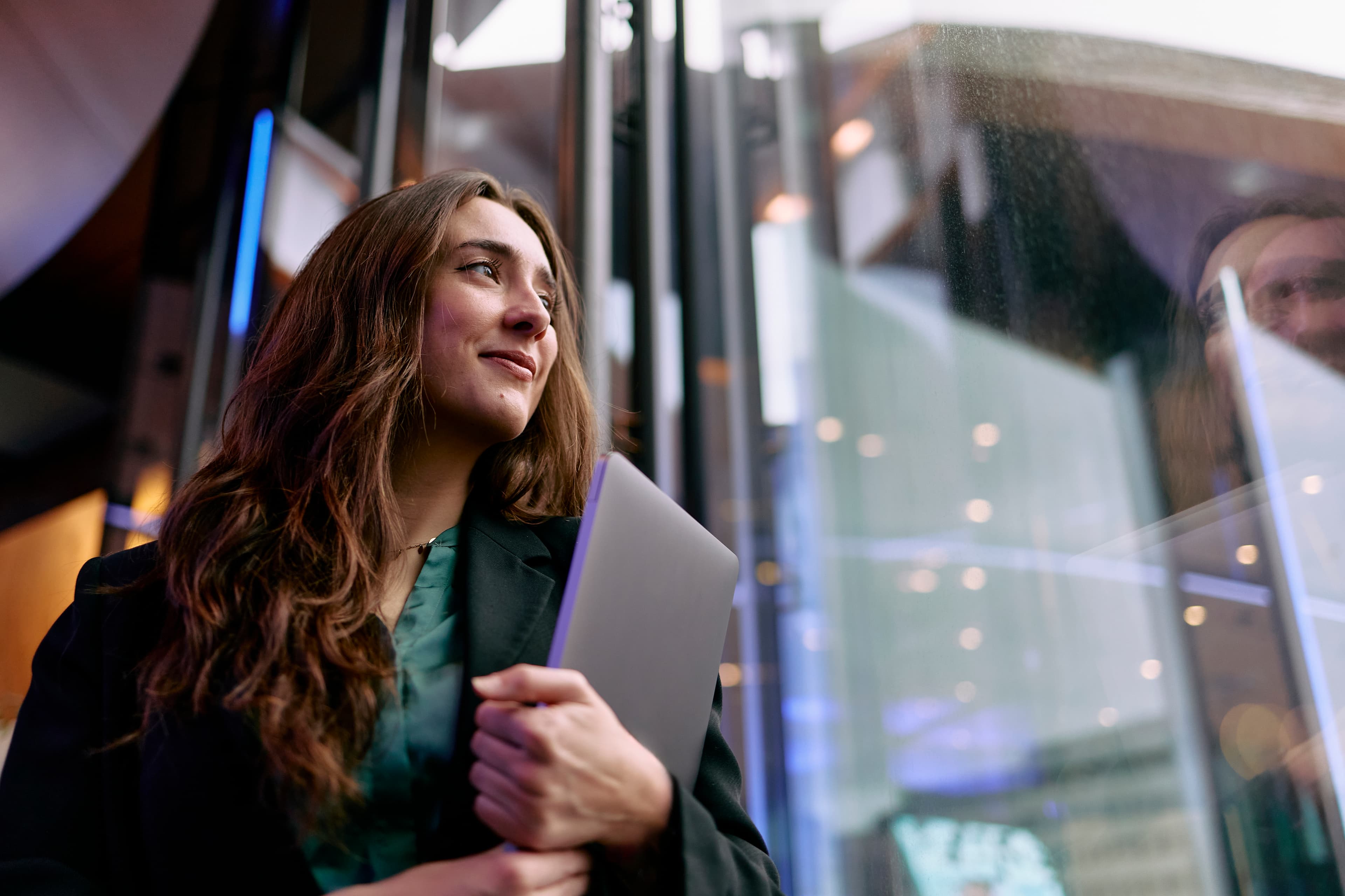 retail executive with laptop looking hopeful in modern office building