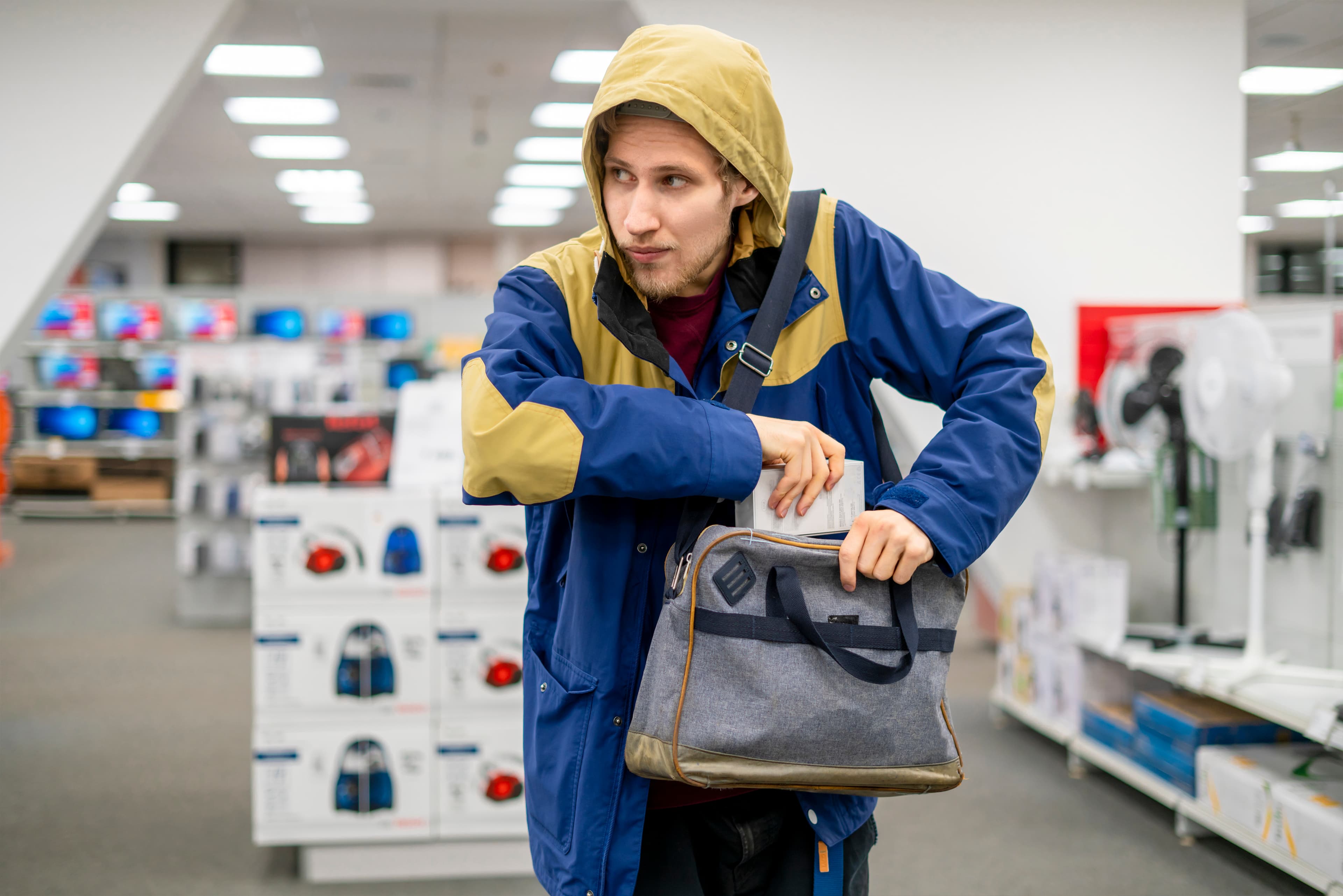 shoplifter in the electronic store supermarket stealing new gadget