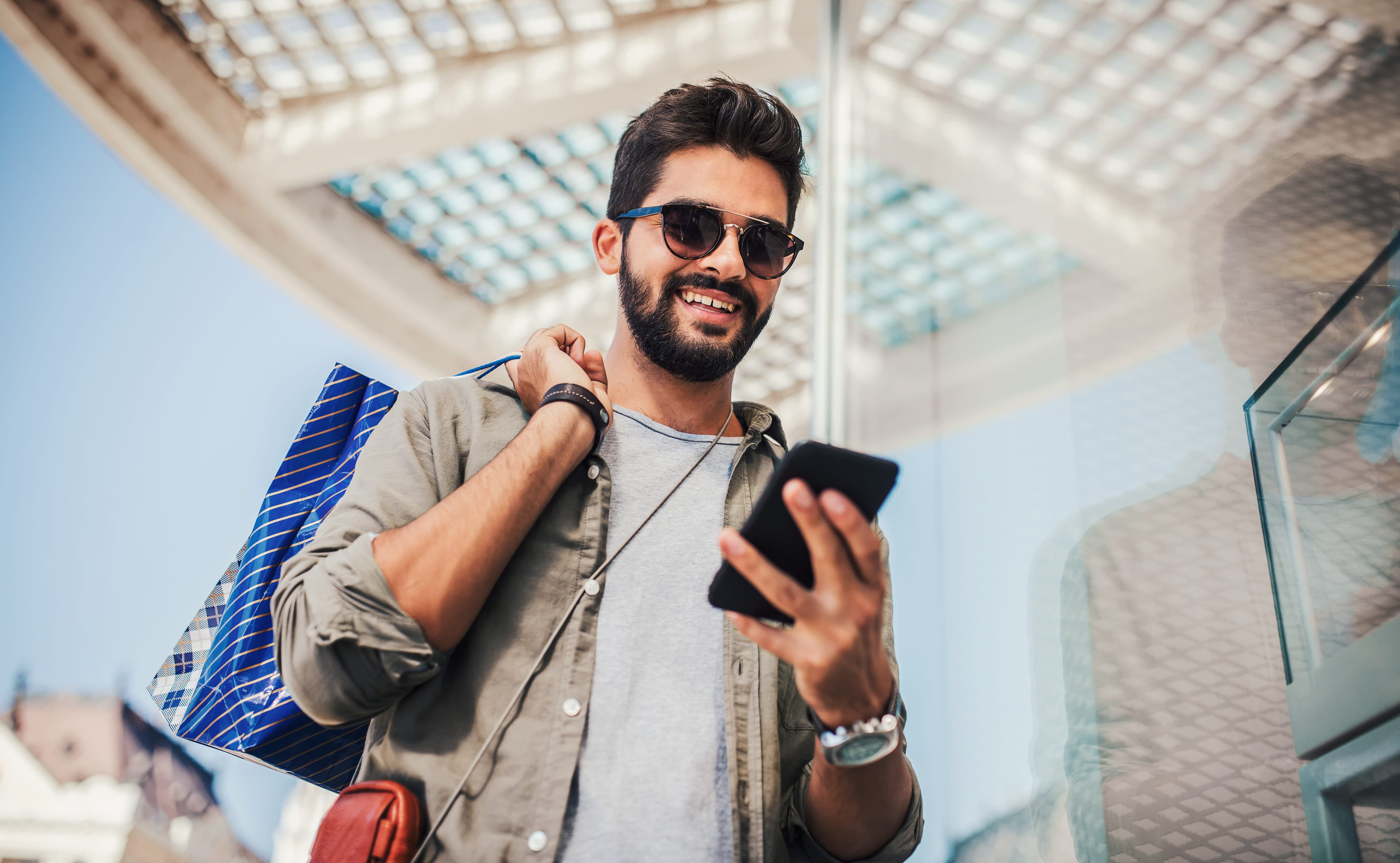 Smiling man with shopping bags enjoying in shopping.