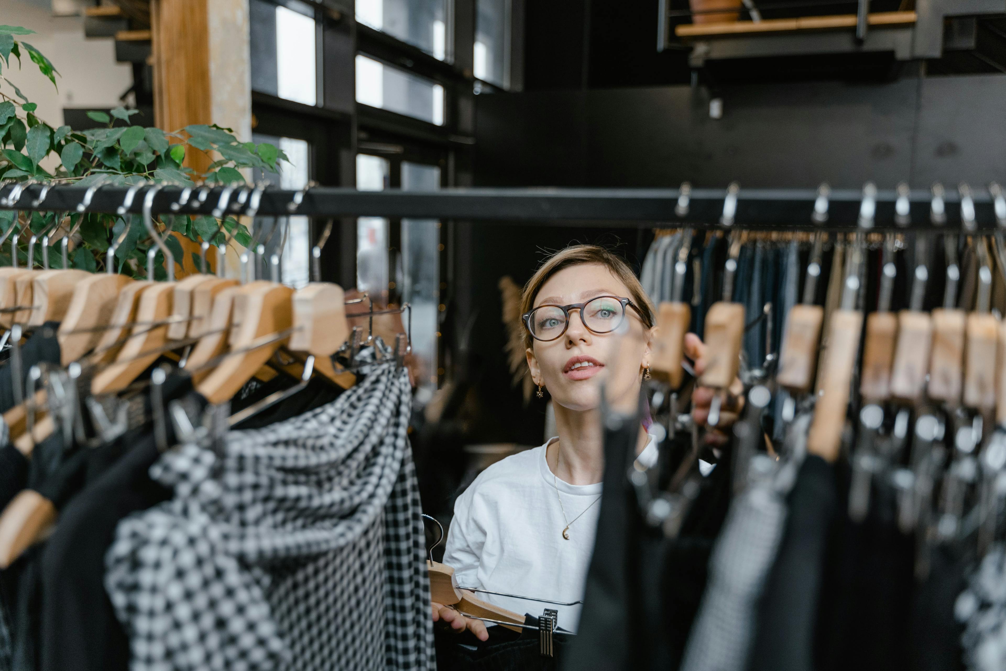 Woman Adding More Clothes on the Clothes Rack in a luxurious retail store