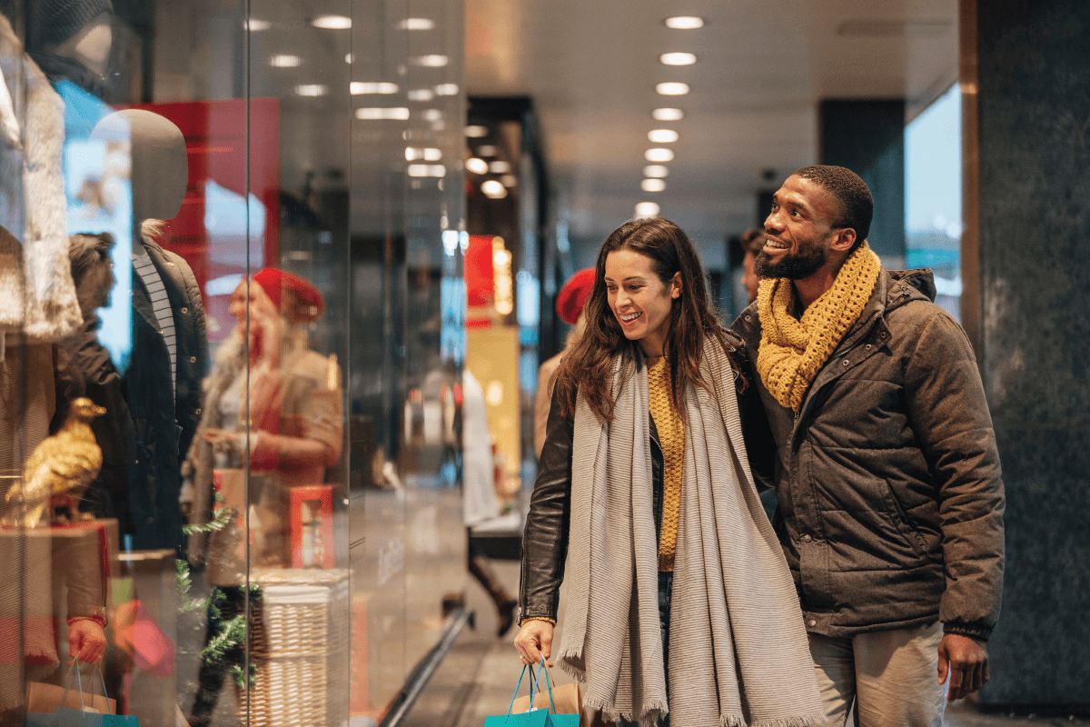 Couple Shopping In Mall Over Black Friday Weekend