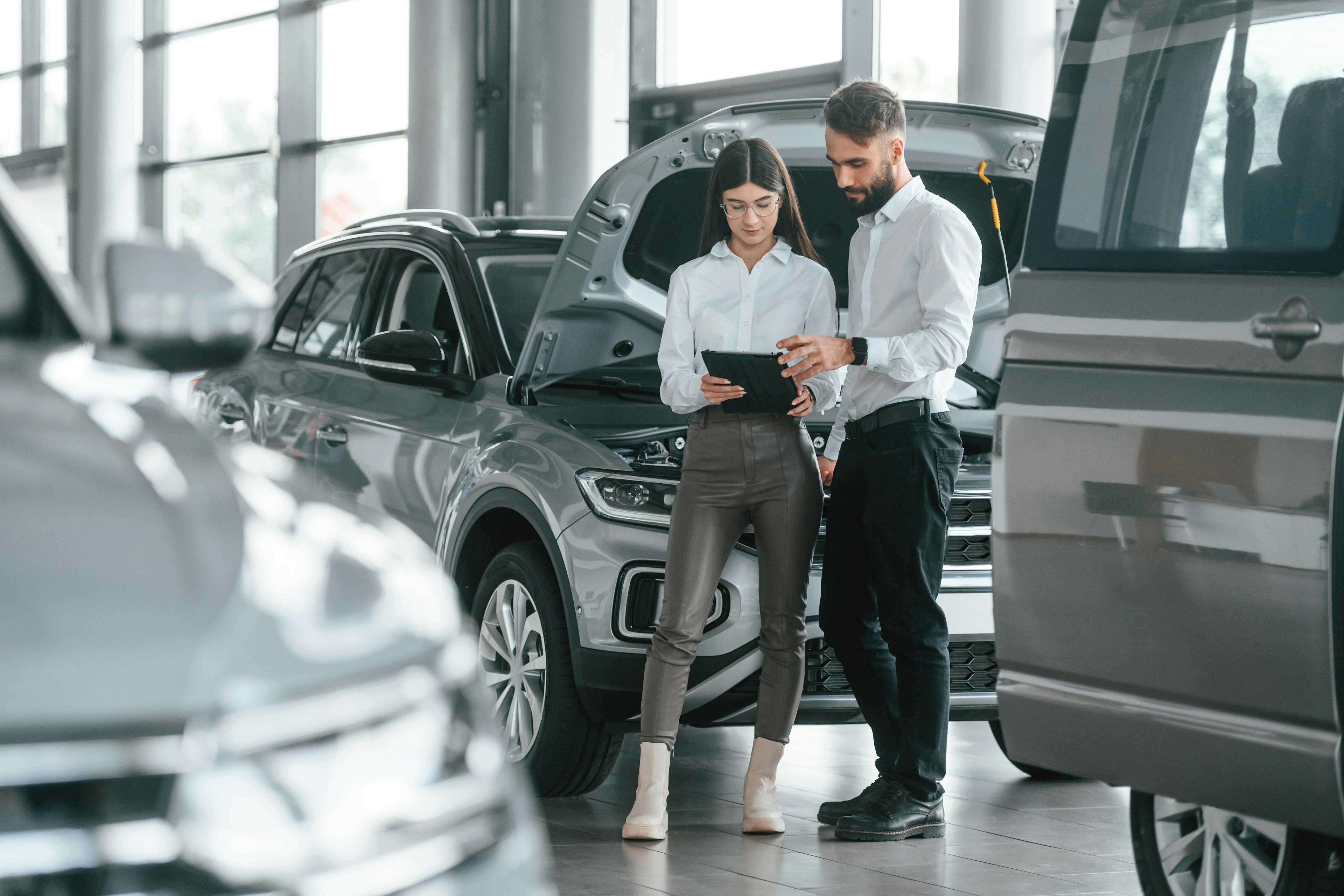 male and female sales associates on a vehicle showroom floor
