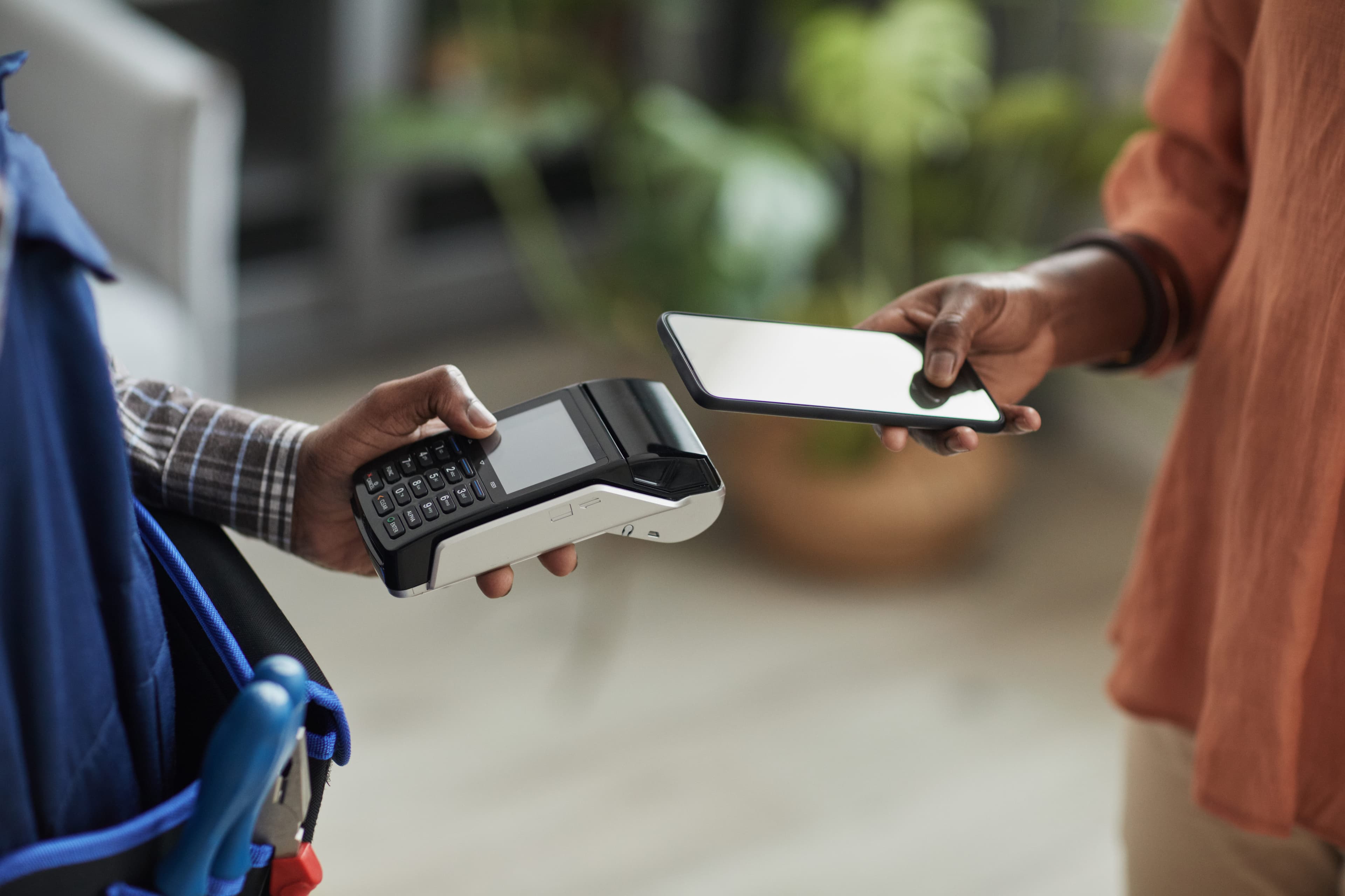 store associate and customer completing mobile payment with smart phone and PoS terminal 