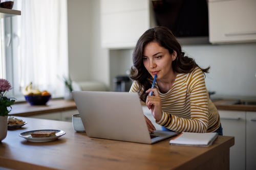  Young woman using a laptop while working from home