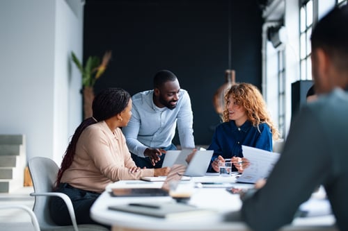A group of colleagues working together in a contemporary office environment, focused on collaboration and teamwork to achieve professional goals.