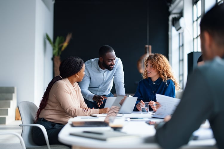 A group of colleagues working together in a contemporary office environment, focused on collaboration and teamwork to achieve professional goals.