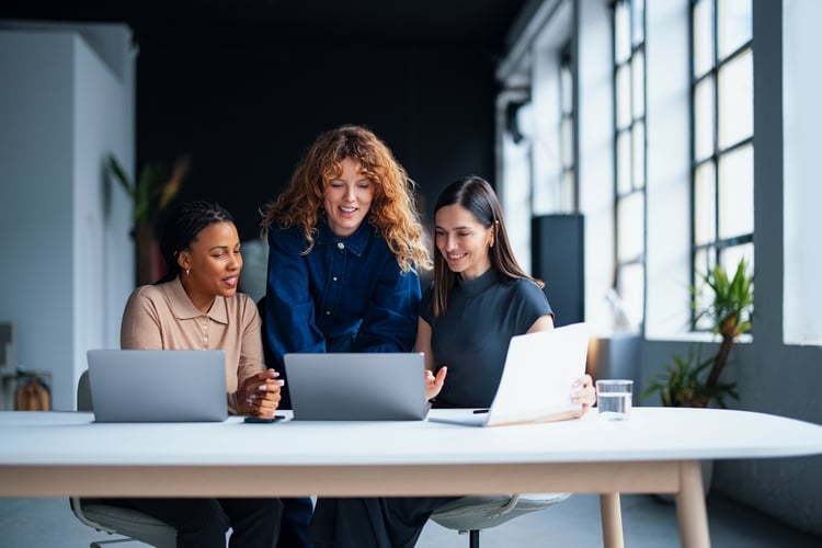 A team of women discussing at a workplace, discussing RetailNext's Pulse AI