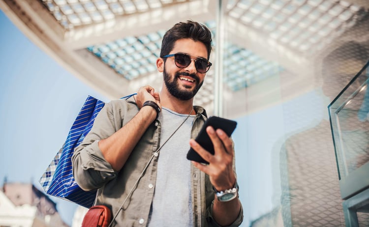 Smiling man with shopping bags enjoying in shopping.