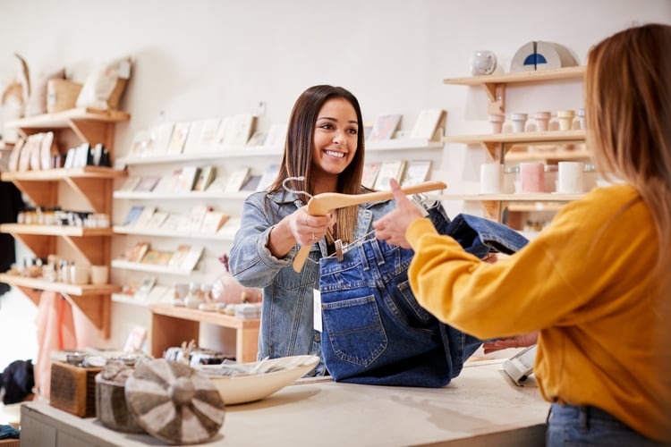 Female Sales Assistant In Clothing And Gift Store Serving Female Customer