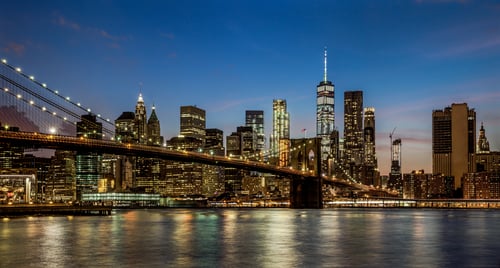 panoramic view new york city downtown manhattan skyline at night with skyscrapers and brooklyn bridge