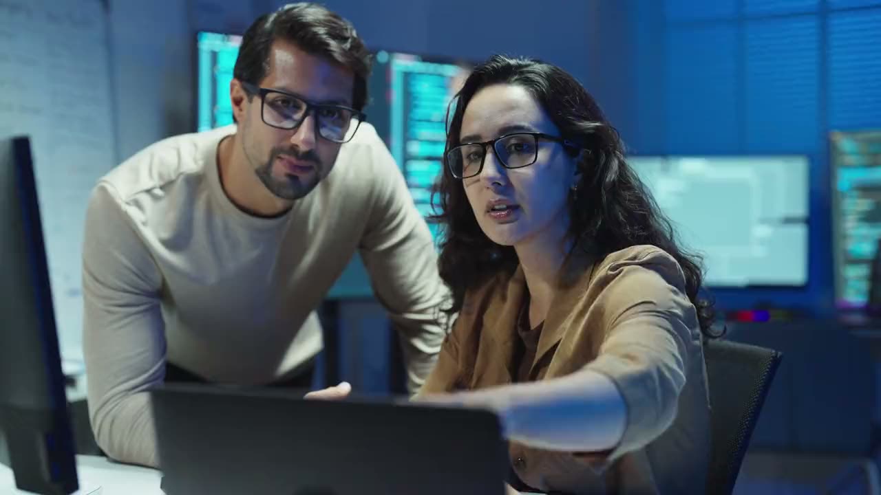 Two analysts reviewing store performance data on screen