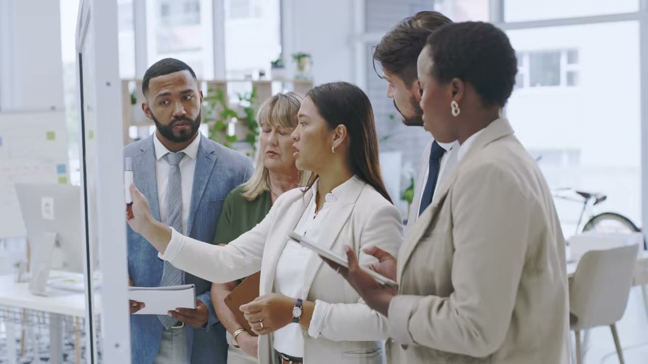 A team at a glass board working through a plan together
